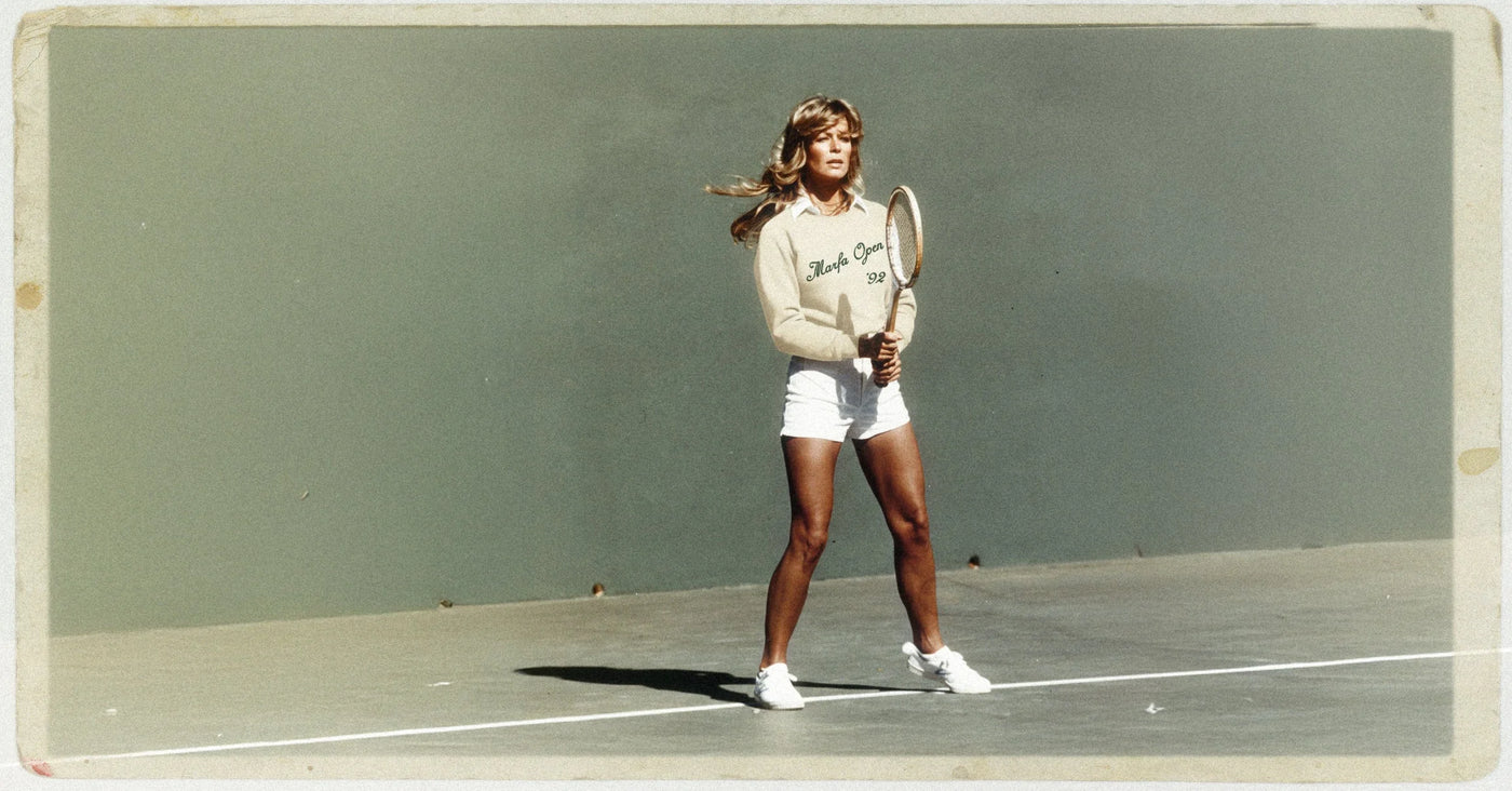 Vintage-style photo of a woman playing tennis on a court.